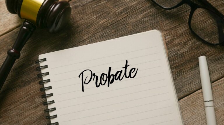 gavel, glasses, pen and notebook with word Probate